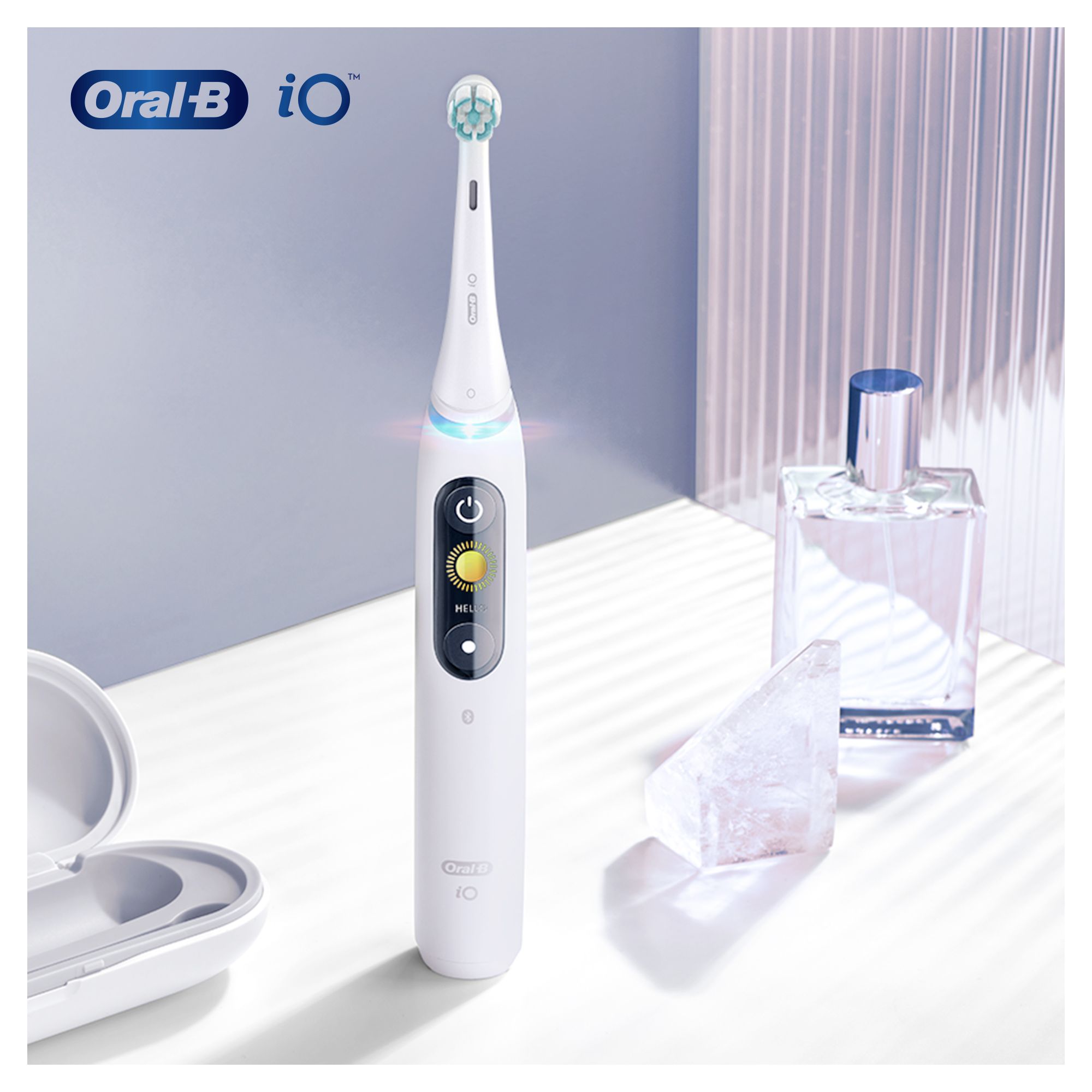 Weiße elektrische Zahnbürste mit Display. Oral-B iO Logo. Zubehör im Hintergrund.