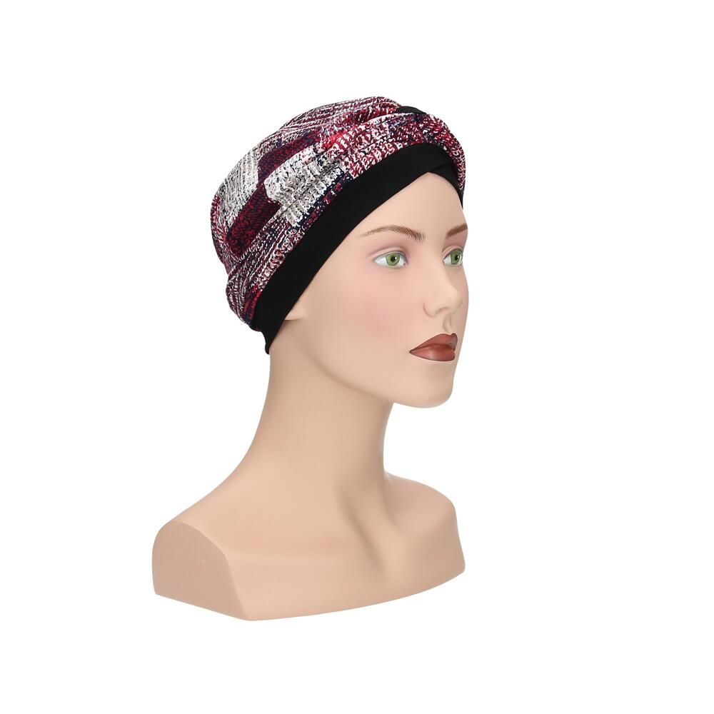 Turban mit mehrfarbigem Muster auf einem Schaufensterpuppenkopf. Schwarzes Stirnband. Seitenansicht.