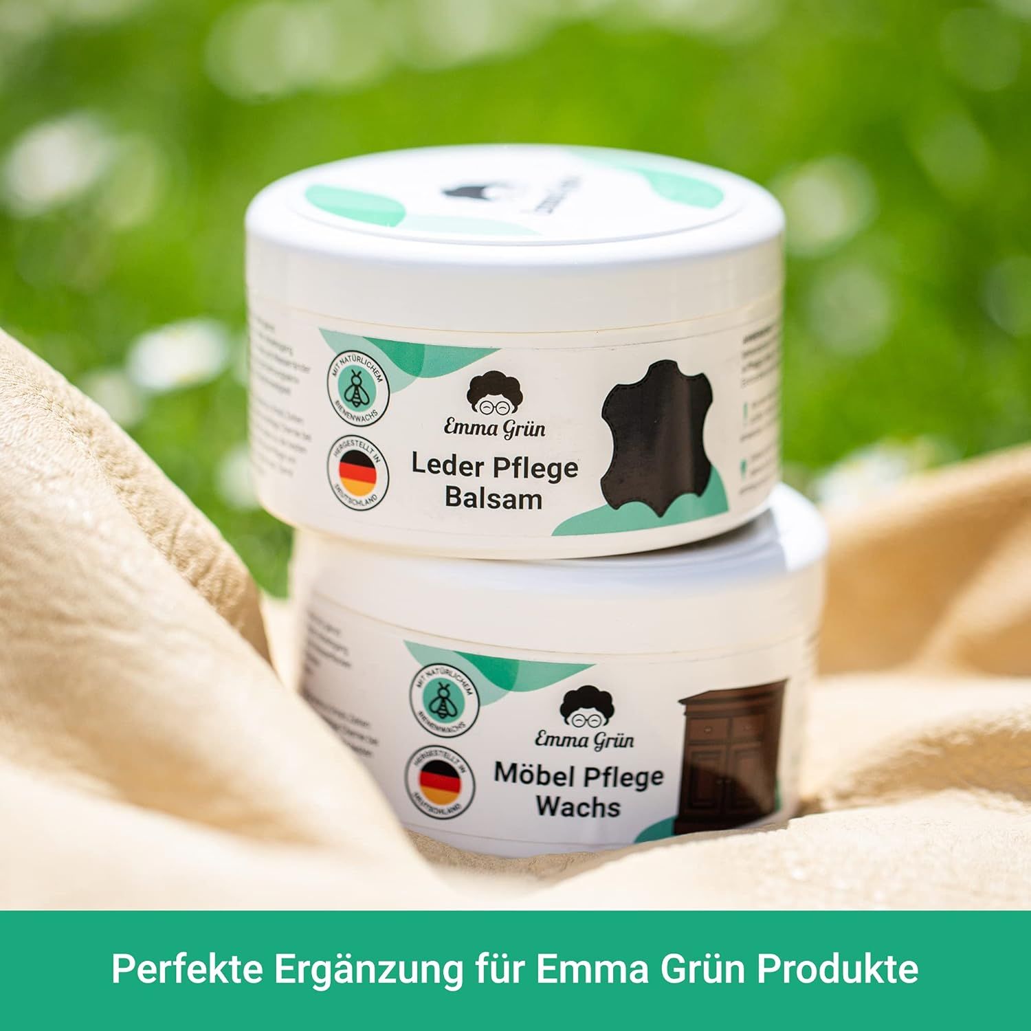 Zwei weiße Tiegel mit Deckel. Aufschrift: Emma Grün Leder Pflege Balsam und Möbel Pflege Wachs. Text: Perfekte Ergänzung.