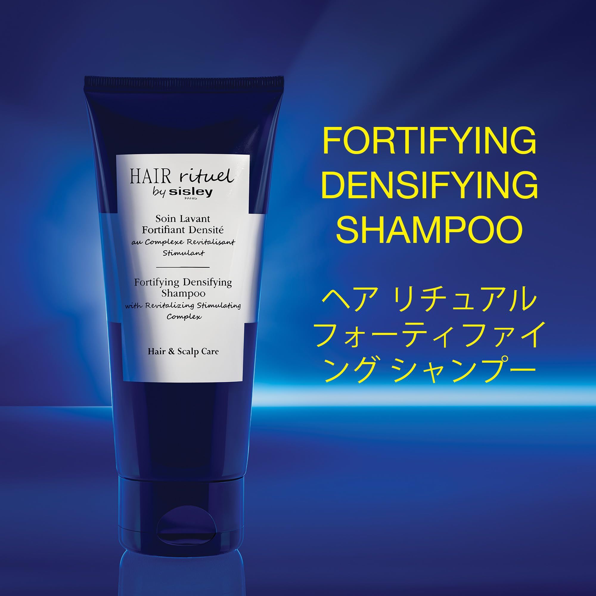 Dunkelblaue Tube mit weißem Etikett. Text: Hair Rituel by Sisley, Fortifying Densifying Shampoo. Japanischer Text.