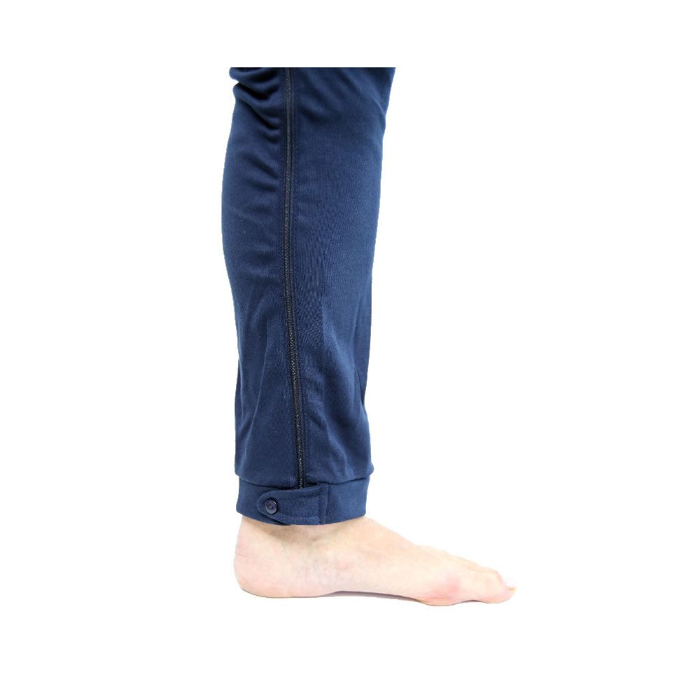 Detailansicht des blauen Overalls. Reißverschluss am Bein, Knopfverschluss am Knöchel. Barfuß stehend.