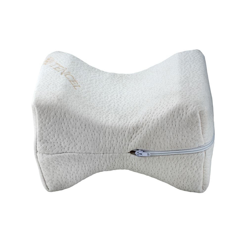 Weißes Bein-Kissen mit Reißverschluss. Geprägtes Material, abgerundete Form. Text: TENCEL.