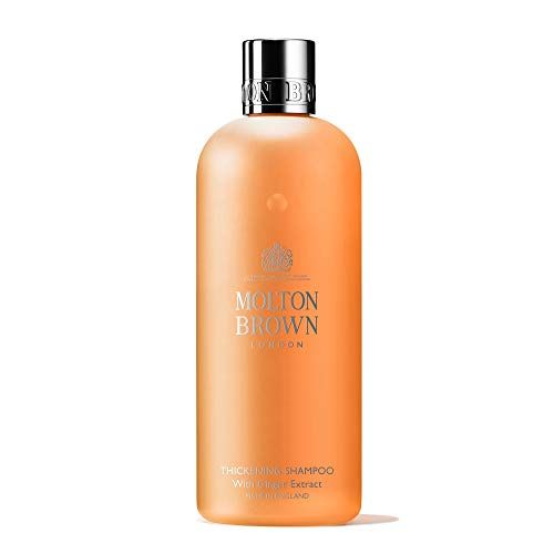 Orangefarbene Shampoo-Flasche mit silbernem Deckel. Aufschrift: Molton Brown London, Thickening Shampoo mit Ingwer Extrakt.