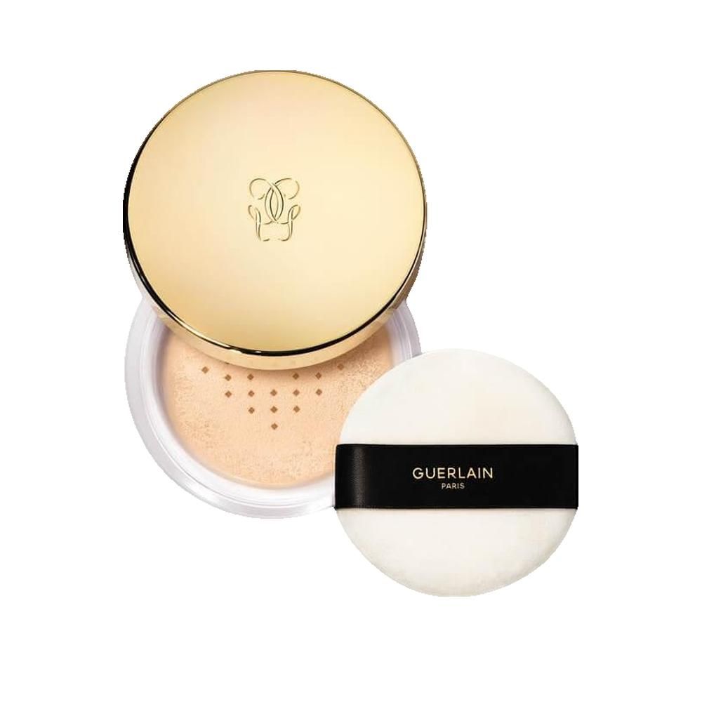 Geöffnete Puder-Dose mit goldenem Deckel und Quaste. Deckel mit Logo. Quaste mit schwarzem Band und Schriftzug Guerlain.