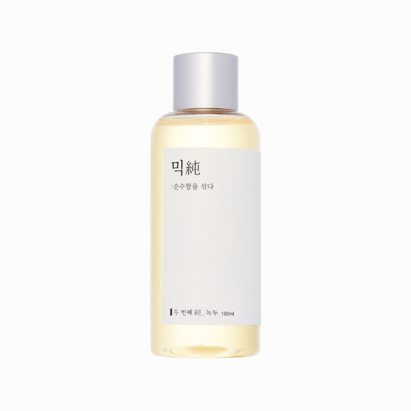Flüssigkeit in einer zylindrischen Flasche mit silbernem Deckel. Aufkleber mit koreanischem Text. Klare Flüssigkeit.