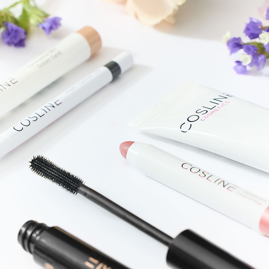 Nahaufnahme von Cosline Make-up-Produkten. Enthält: Mascara, Eyeliner, Lidschattenstift, Lippenstift, Foundation. Auf hellem Hintergrund.