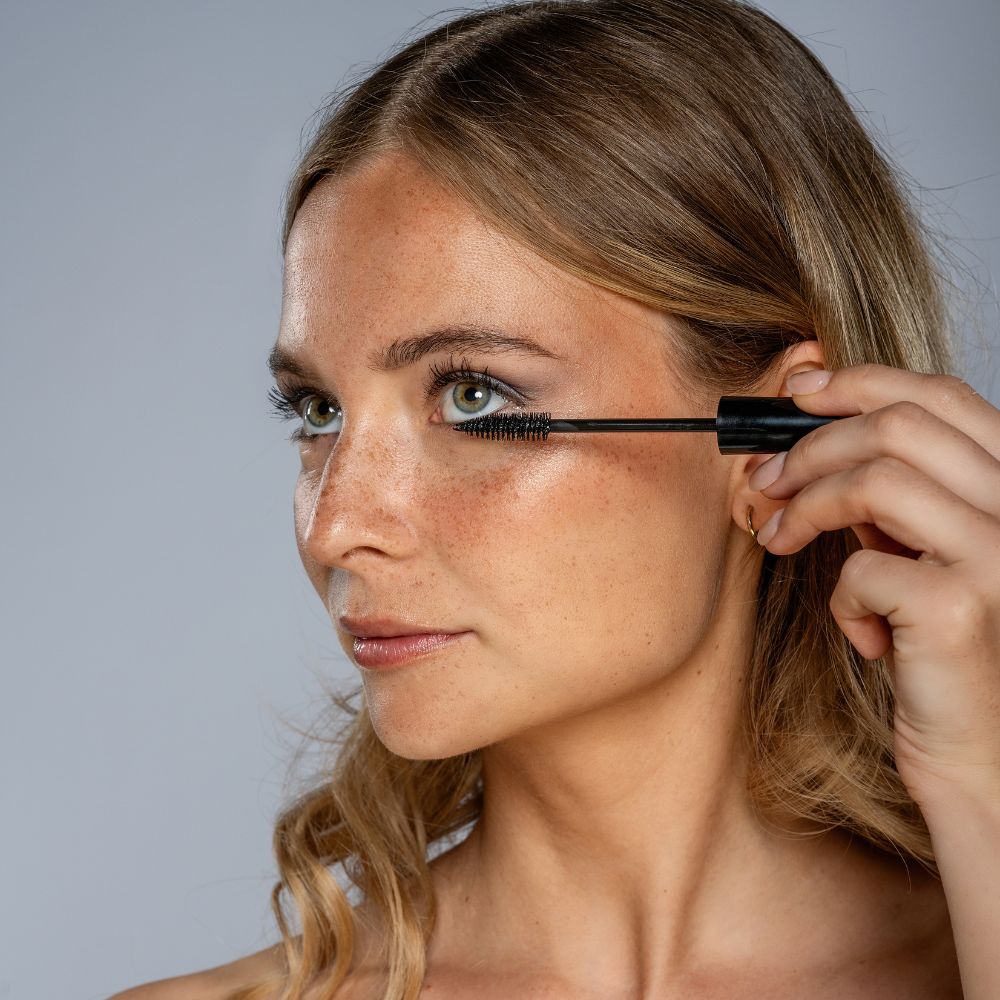 Frau mit Sommersprossen trägt Benecos Natural Mascara Glamour Look auf.