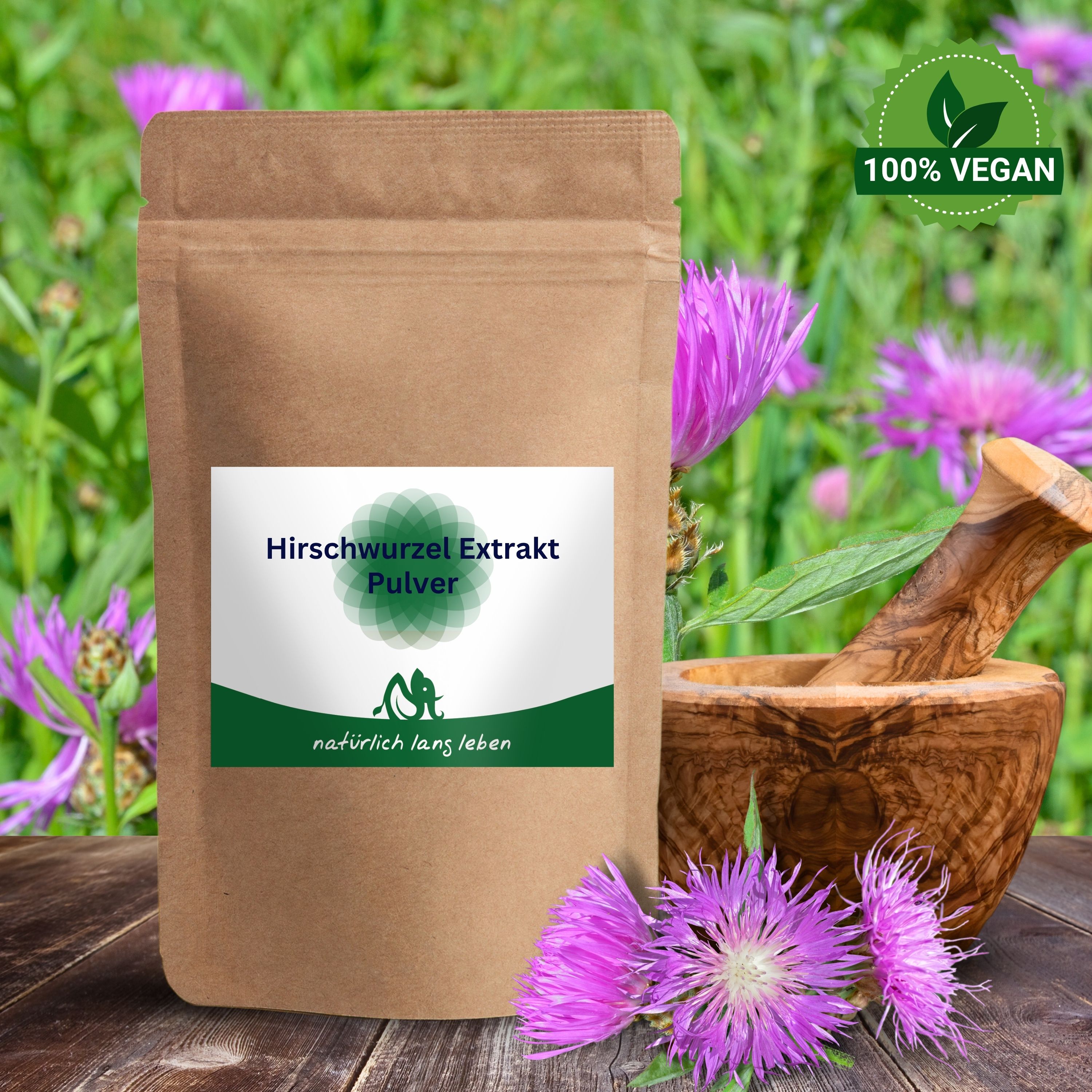 Braune Tüte mit Etikett. Aufschrift: Hirschwurzlextrakt Pulver. Logo: grünes Blattmuster. 100% Vegan-Siegel. Blumen und Mörser im Hintergrund.