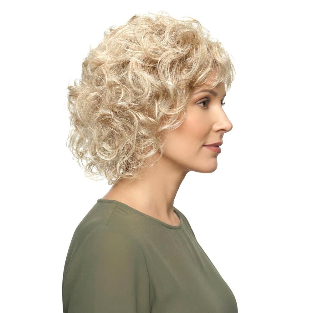 Perücke mit lockigem, blondem Haar. Die Frau trägt ein grünes Oberteil. Seitenansicht.