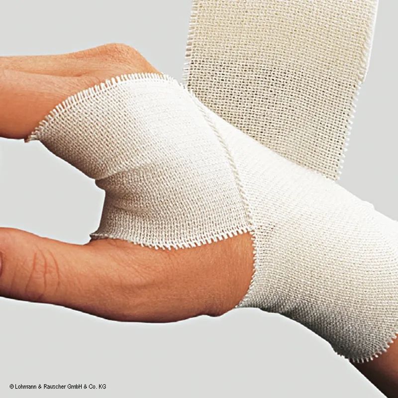 Hand mit Verband. Der Verband ist aus weißem Stoff und um das Handgelenk gewickelt.