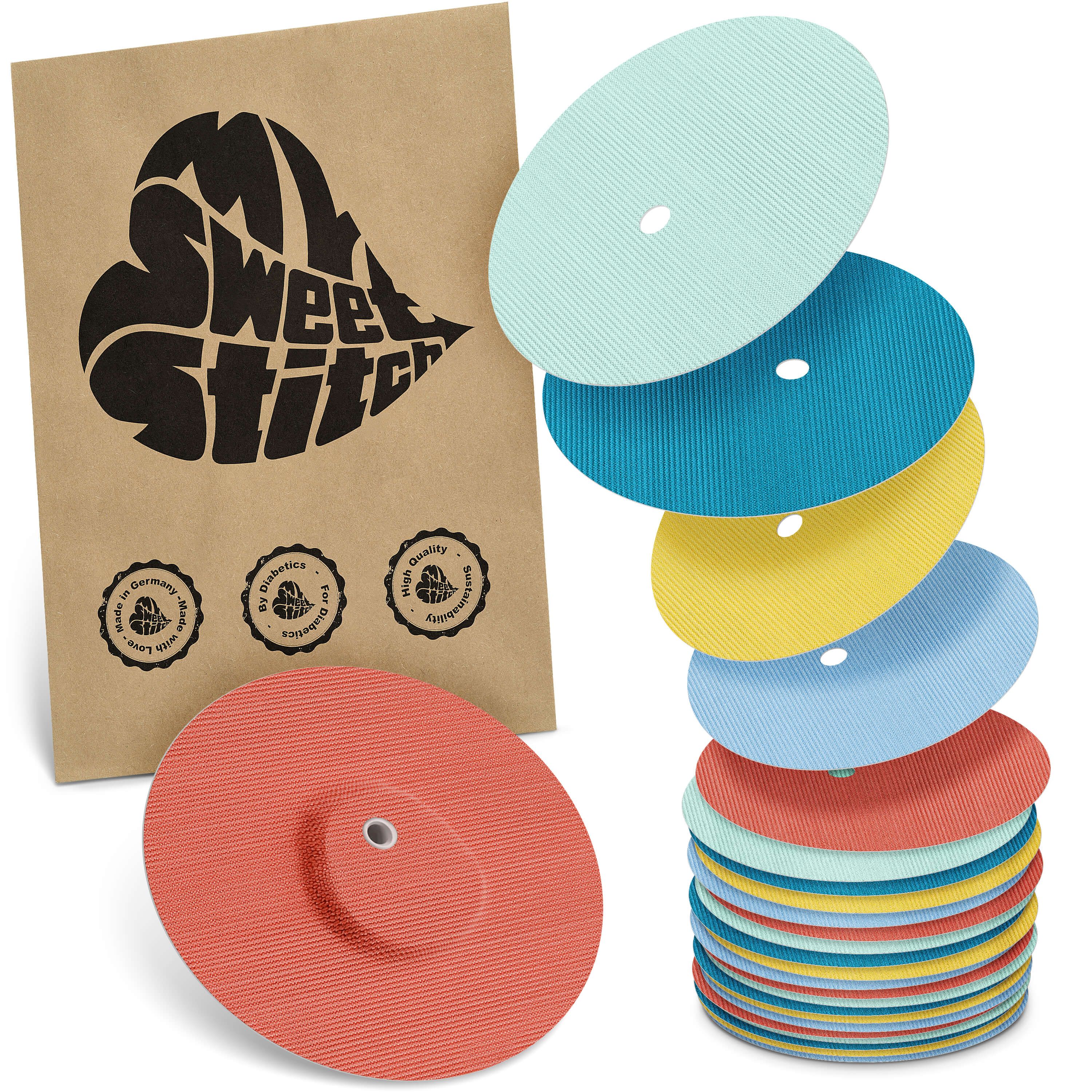 Verschiedenfarbige runde Pflaster mit Loch, neben einer braunen Verpackung mit Logo.
