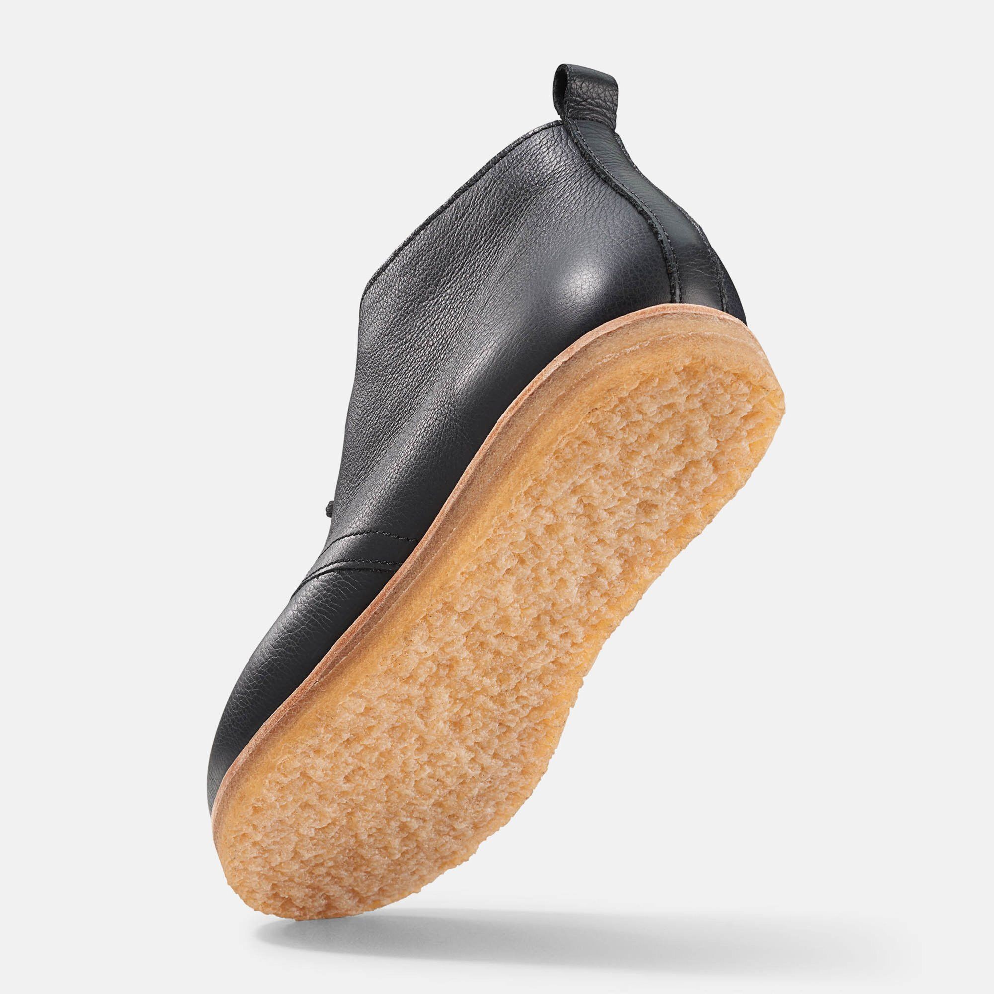 Schwarzer Stiefelette mit Schnürsenkeln und heller Sohle. Lederoptik. Unteransicht, leicht erhöht.