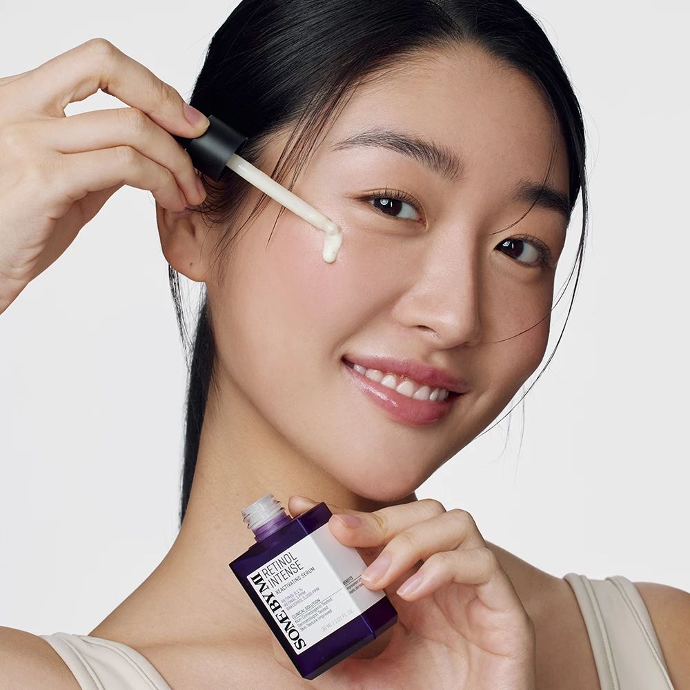 Frau mit Serumflasche und Applikator. Produktname und Text sind sichtbar.