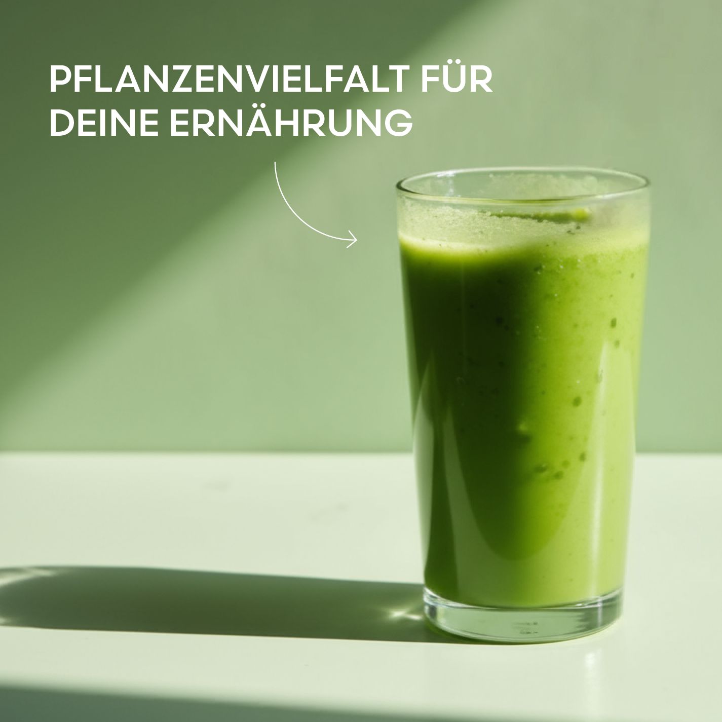 Glas mit grünem Getränk. Aufschrift: Pflanzenvielfalt für deine Ernährung. Helles Hintergrundbild.