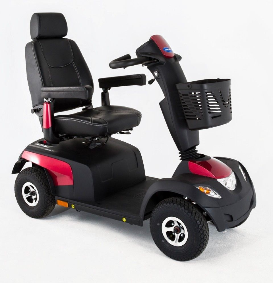 Invacare Elektromobil Comet Pro, rubinrot. Schwarzer Sitz, Korb, Lenker. Vier Räder, roter und schwarzer Rahmen. Marke sichtbar.