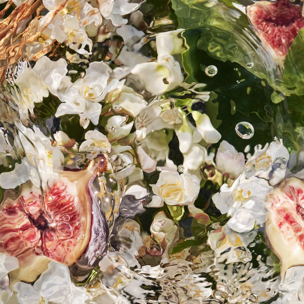 Nahaufnahme von Blumen, Früchten und Wasser. Keine Produkte oder Marken sichtbar.