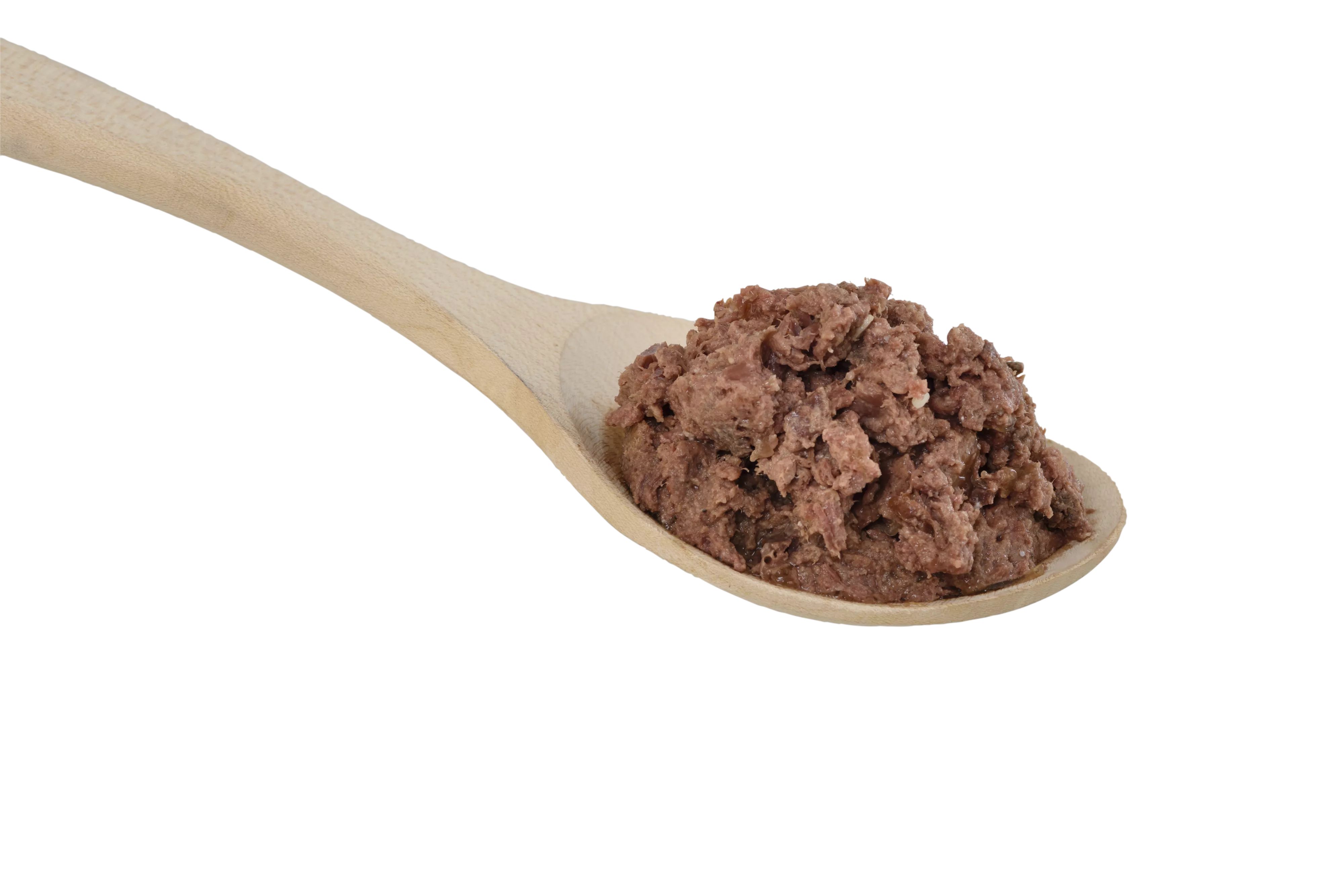 Hundefutter auf einem Holzlöffel. Das Futter ist braun und stückig.