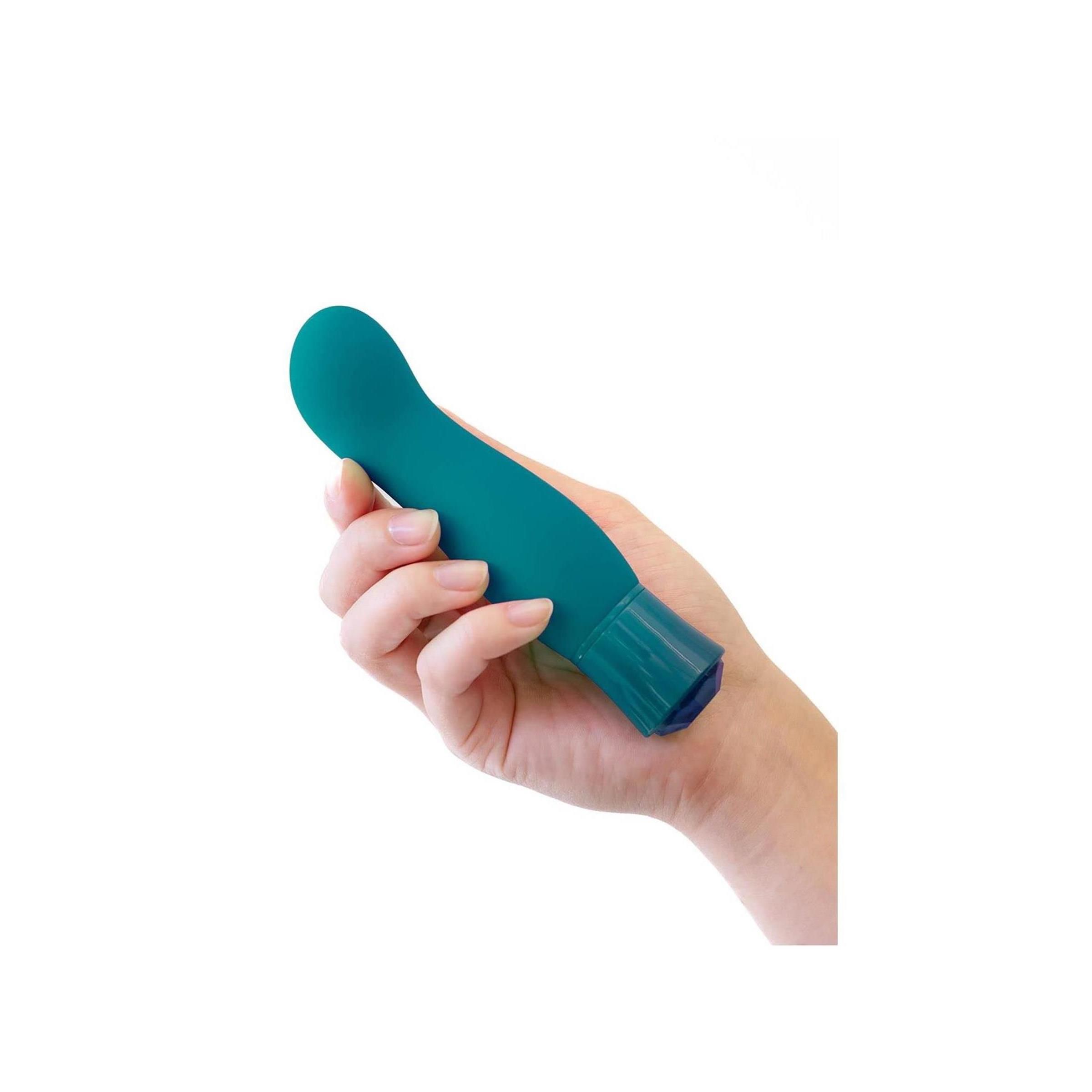 Türkisfarbener Vibrator in einer Hand gehalten.