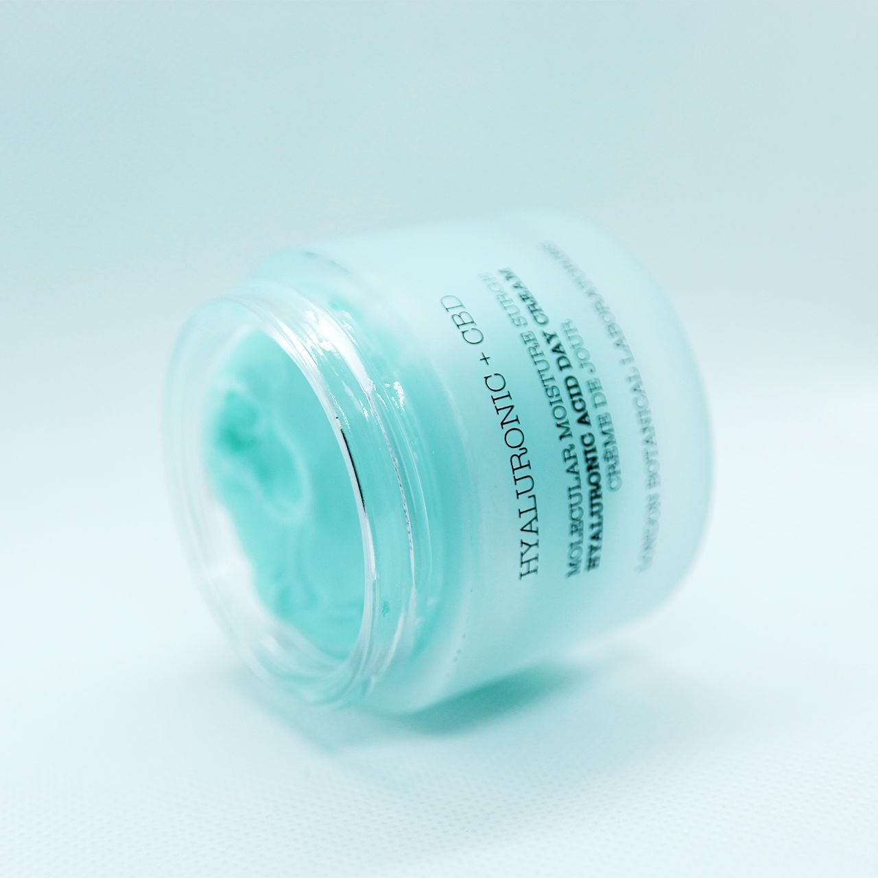 Gekippter Tiegel mit Hyaluronsäure + CBD Feuchtigkeitscreme. Blauer Tiegel mit silbernem Deckel.