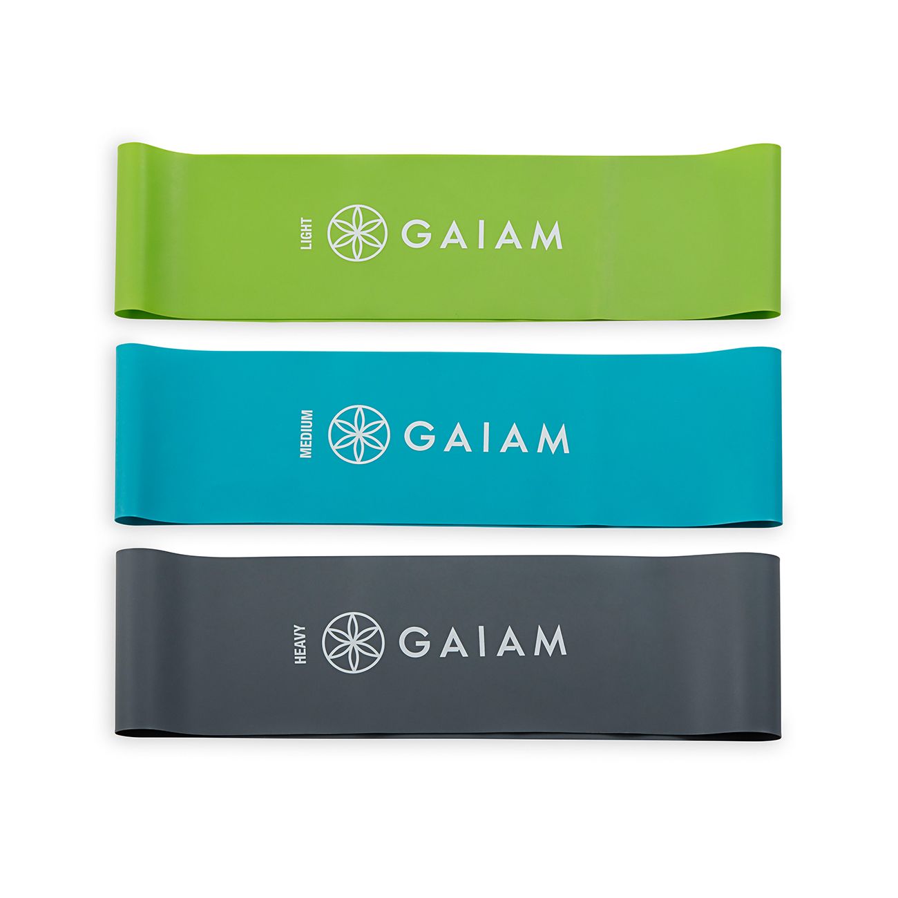 Drei farbige Fitnessbänder. Grün: Light, blau: Medium, grau: Heavy. Marke: Gaiam. Aufschrift auf jedem Band.