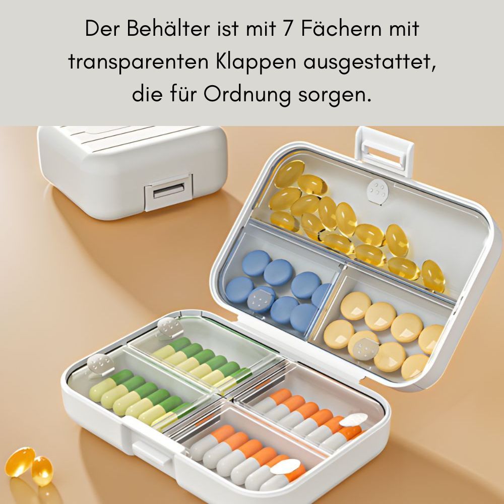 Geöffnete, weiße Tablettenbox mit transparenten Fächern, gefüllt mit Pillen. Zusätzliche Box im Hintergrund.
