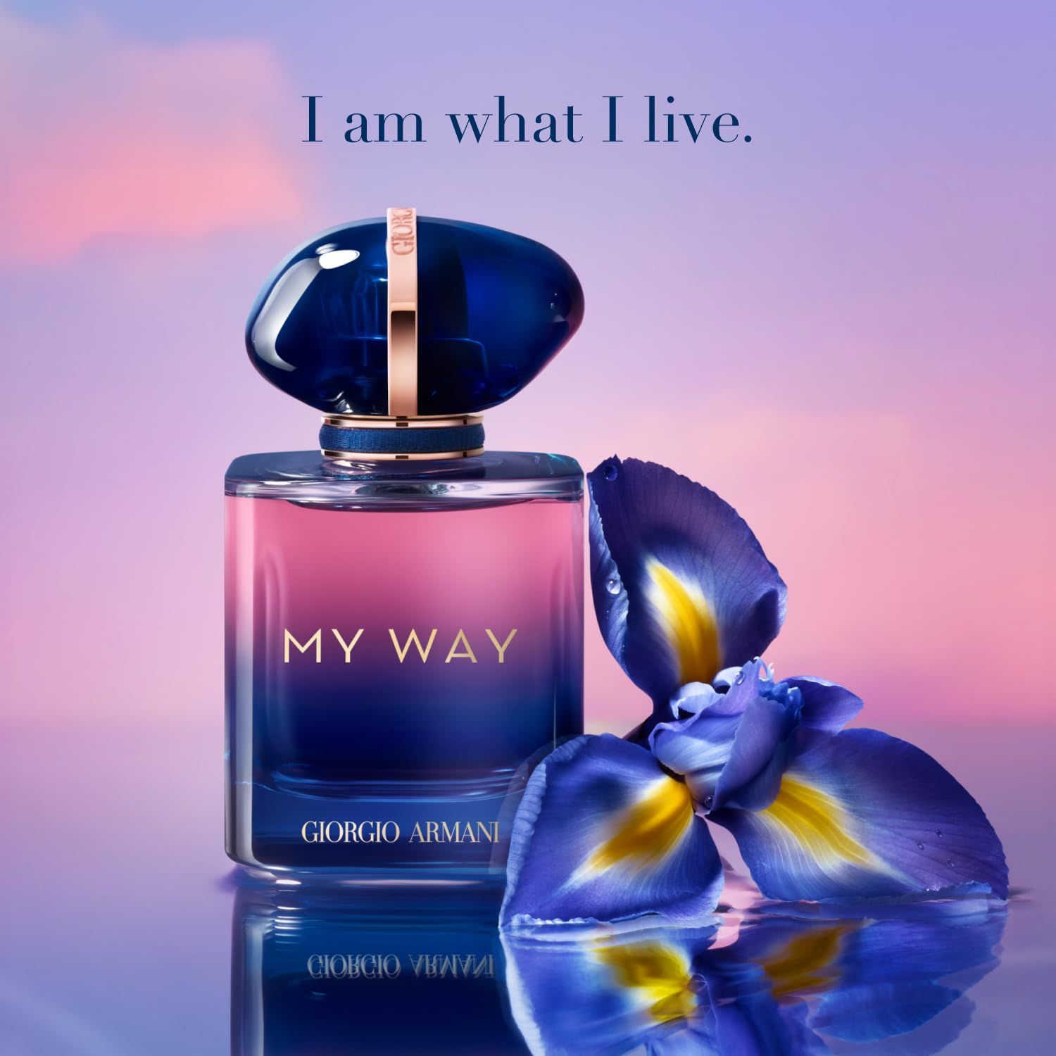 Parfümflakon mit blauer Kappe und "MY WAY" Schriftzug. "Giorgio Armani" ist ebenfalls sichtbar. Hintergrund mit Blüten.