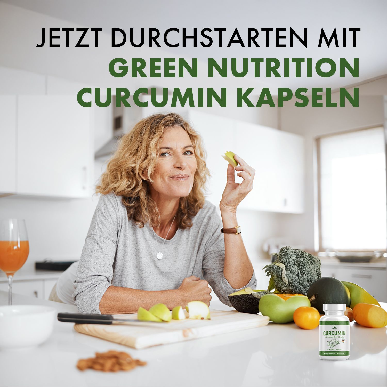Frau in Küche hält Apfelstück. Dose: CURCUMIN Kapseln. Auf Tisch: Gemüse, Obst, Messer. Text: JETZT DURCHSTARTEN MIT GREEN NUTRITION CURCUMIN KAPS.