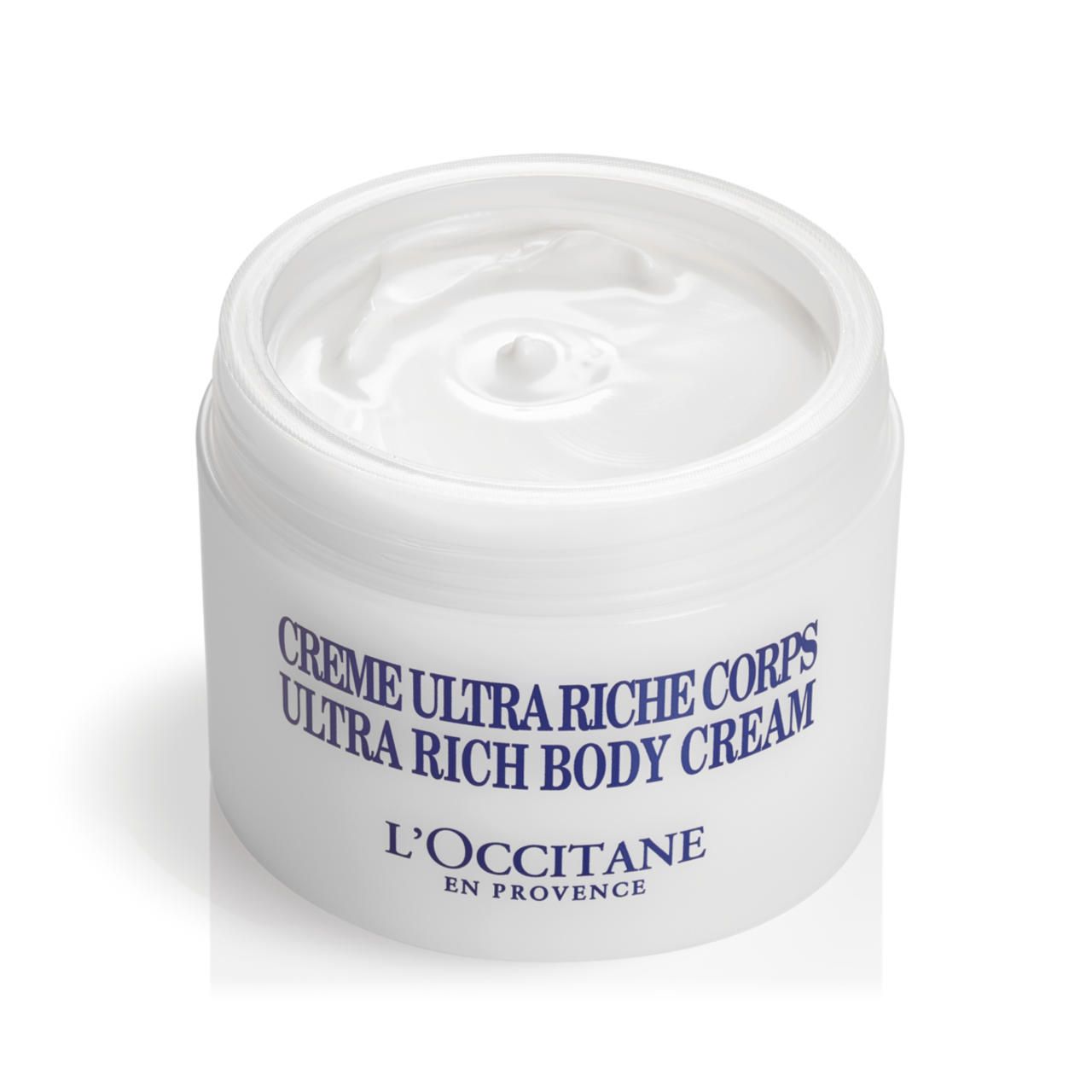 Weißer Tiegel, geöffnet. Aufschrift: Crème Ultra Riche Corps, L'Occitane. Creme sichtbar.