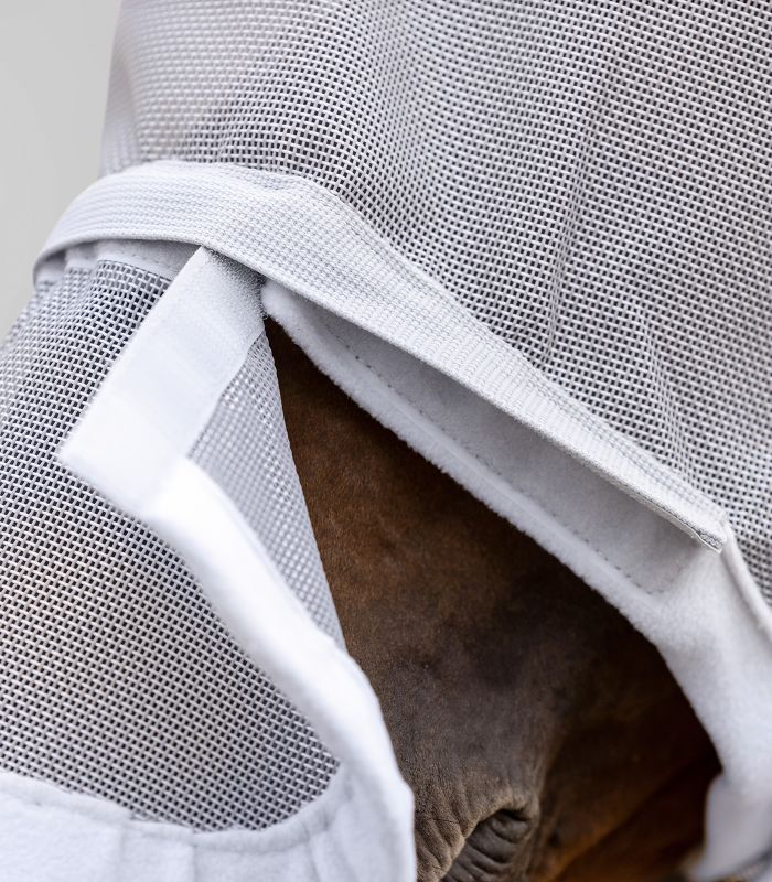 Detailaufnahme einer grauen Fliegenmaske mit Ohren- und Nasenschutz. Netzstoff und weißer Rand.