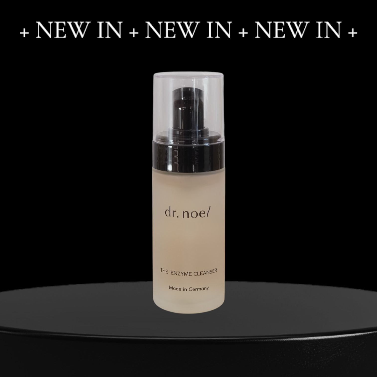 Flasche mit Sprühkopf. Aufschrift: dr. noel/ THE ENZYME CLEANSER. Hergestellt in Deutschland. Auf schwarzem Podest.
