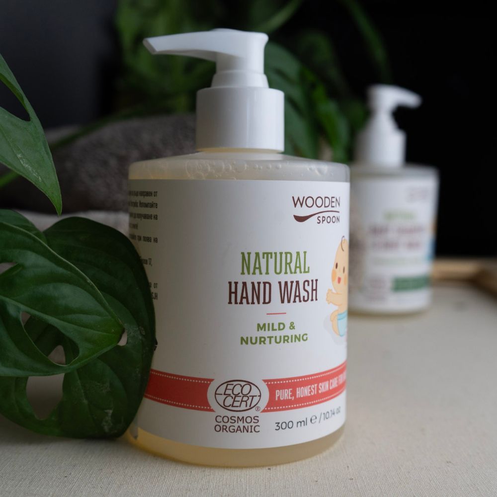 Zwei Flüssigseife-Flaschen mit Pumpe. Etikett mit "NATURAL HAND WASH", Baby-Illustration und "COSMOS ORGANIC"-Zertifizierung. 300 ml.