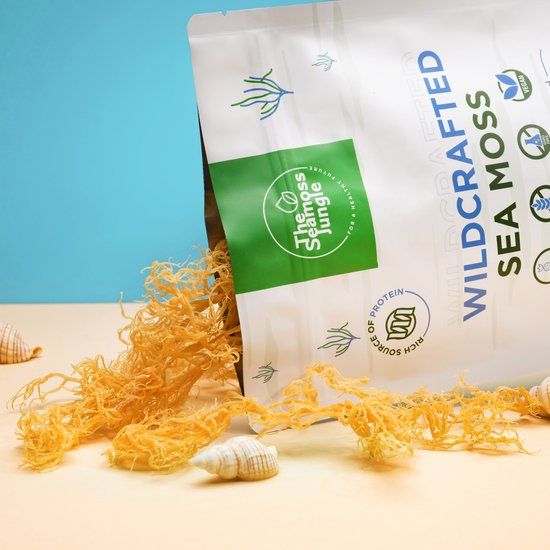 Beutel "The Seamoss Jungle" und "Wildcrafted Sea Moss". Getrocknetes Seemoos quillt heraus. Muscheln liegen daneben.