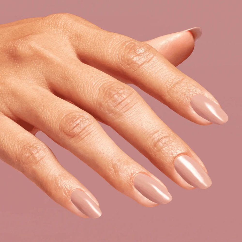 Hand mit lackierten Nägeln in einem rosabraunen Farbton. Glänzendes Finish.