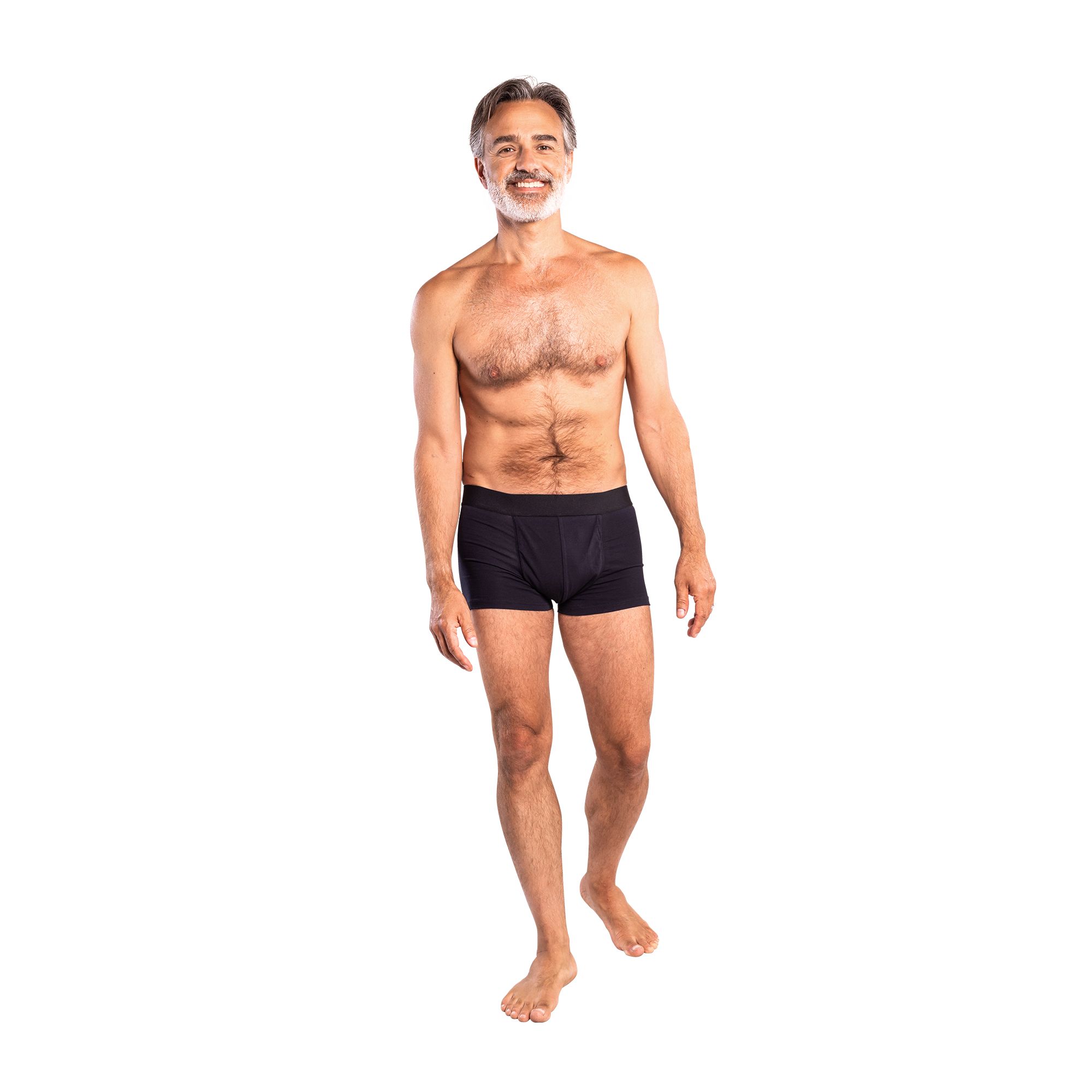 Mann mit grauen Haaren und Bart, trägt schwarze Inkontinenz-Boxershorts. Geht auf den Betrachter zu.