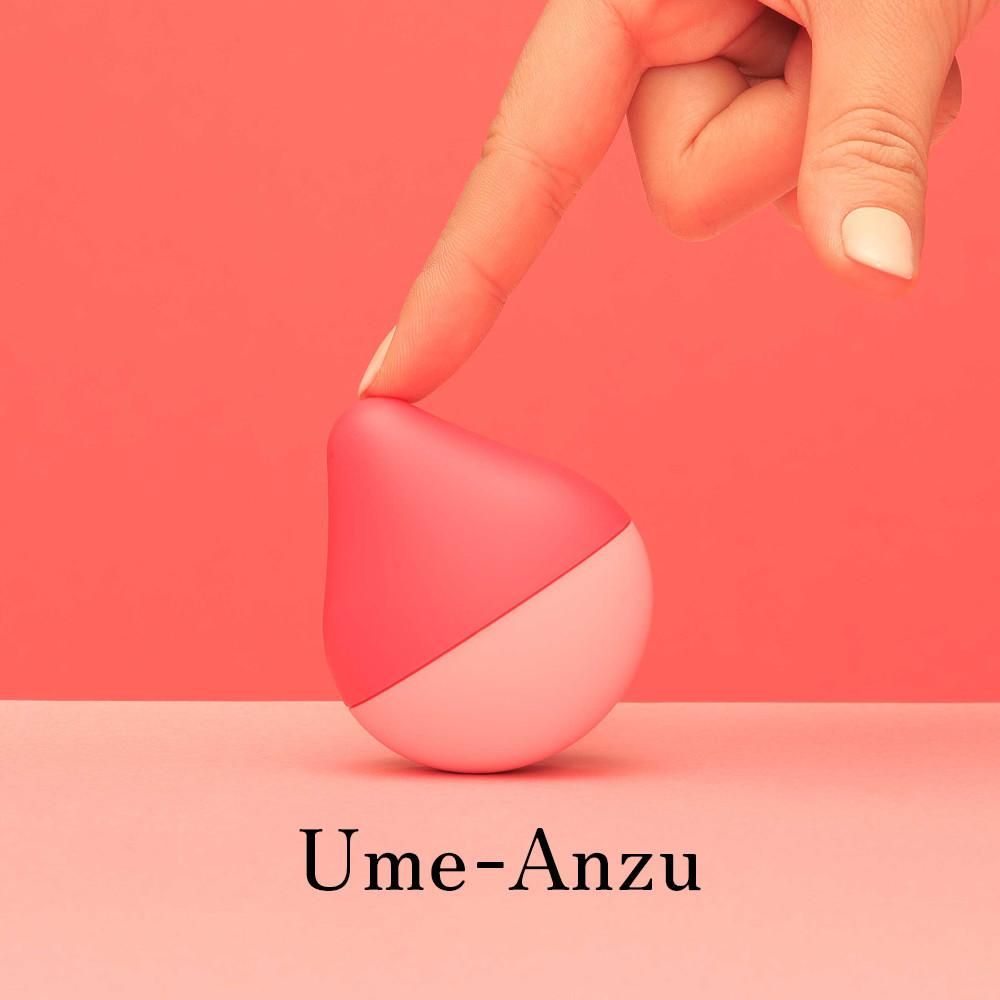 Produkt in Form einer Tropfenform, zweifarbig. Ein Finger berührt das Objekt. Aufschrift: Ume-Anzu.
