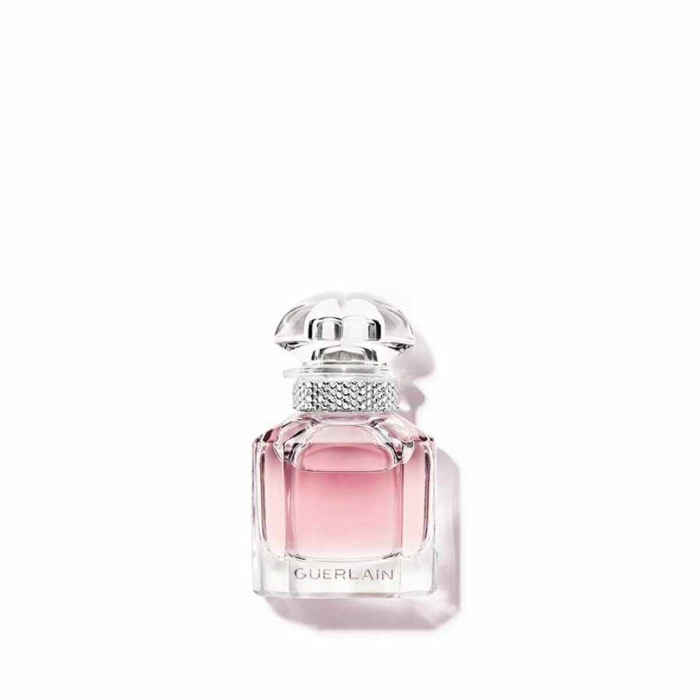 Glasflakon mit rosa Flüssigkeit. Transparenter Deckel. Silberfarbener Ring am Flaschenhals. "GUERLAIN" am Boden.