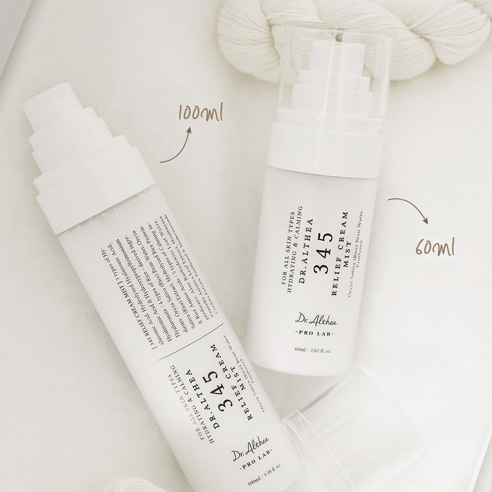 Zwei weiße Sprühflaschen mit Hautpflegeprodukten, eine 100ml, die andere 60ml.