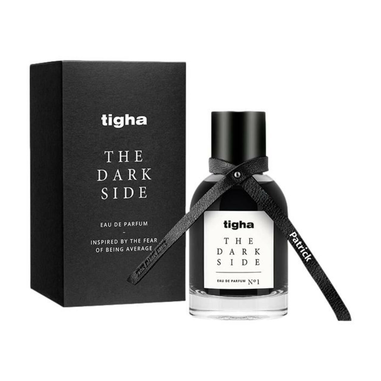 Schwarze Flasche und Verpackung von tigha, The Dark Side EdP. Flasche mit schwarzem Verschluss und Band. Verpackung mit Text.