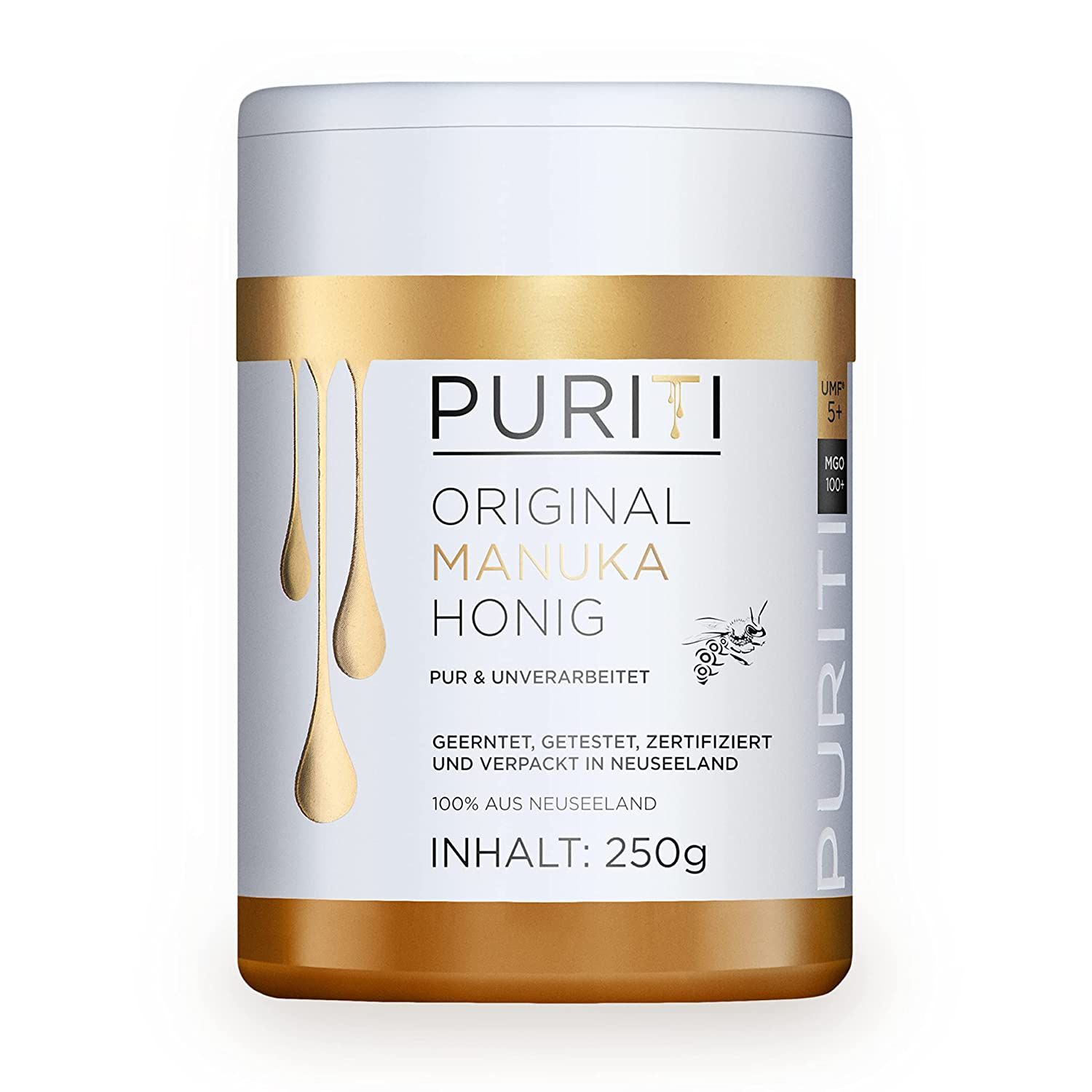 Weiß-goldene Dose mit Aufschrift PURITI ORIGINAL MANUKA HONIG. Tropfendes Honig-Design. Text: 250g, 100% aus Neuseeland.