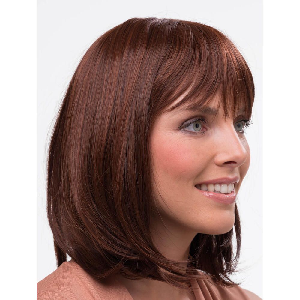 Frau mit braunem Haarteil mit Pony. Das Haar ist schulterlang und glatt. Die Frau lächelt.
