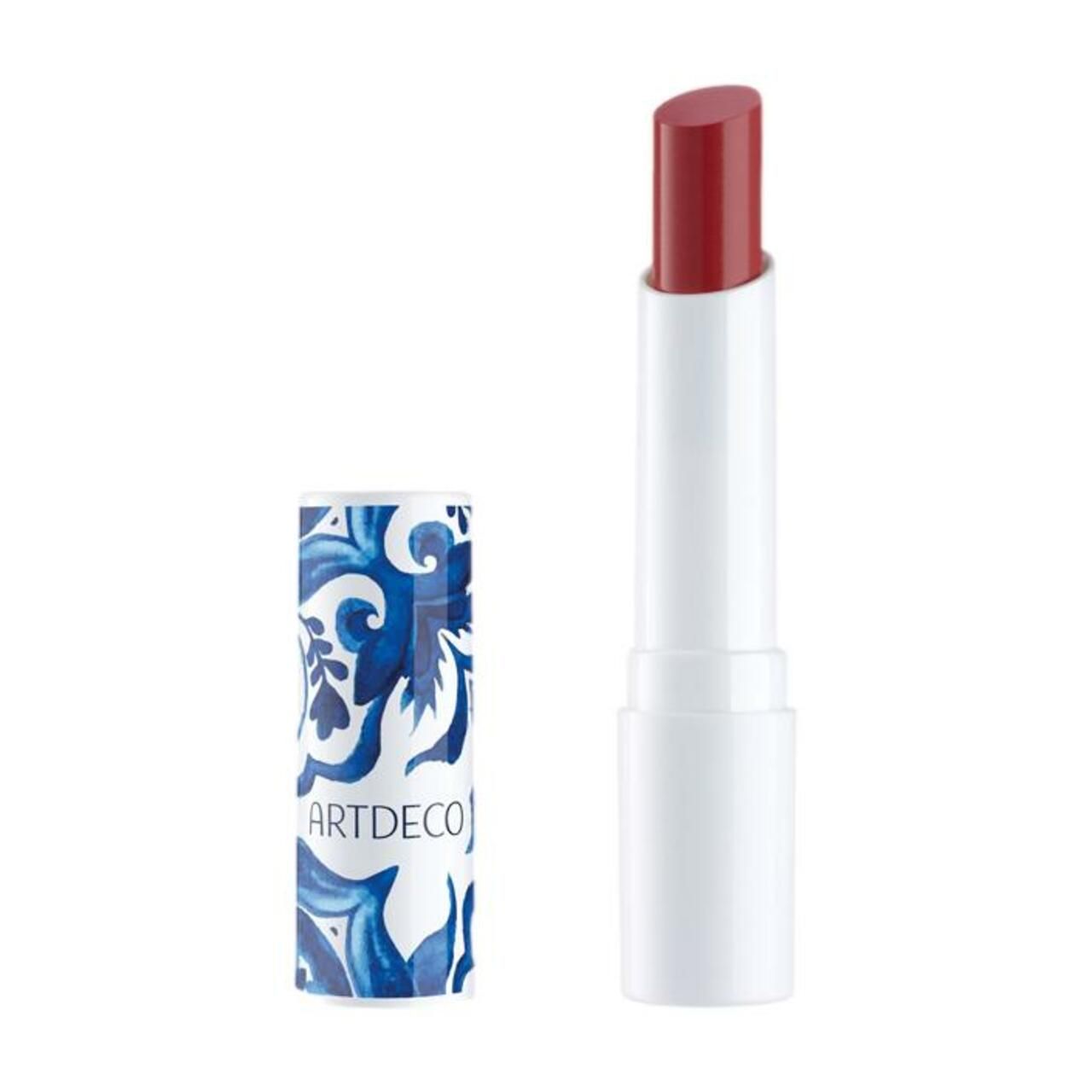 Lippenbalsam. Weißer Stift mit rotem Lippenstift. Deckel mit blauem Muster und ARTDECO-Schriftzug.