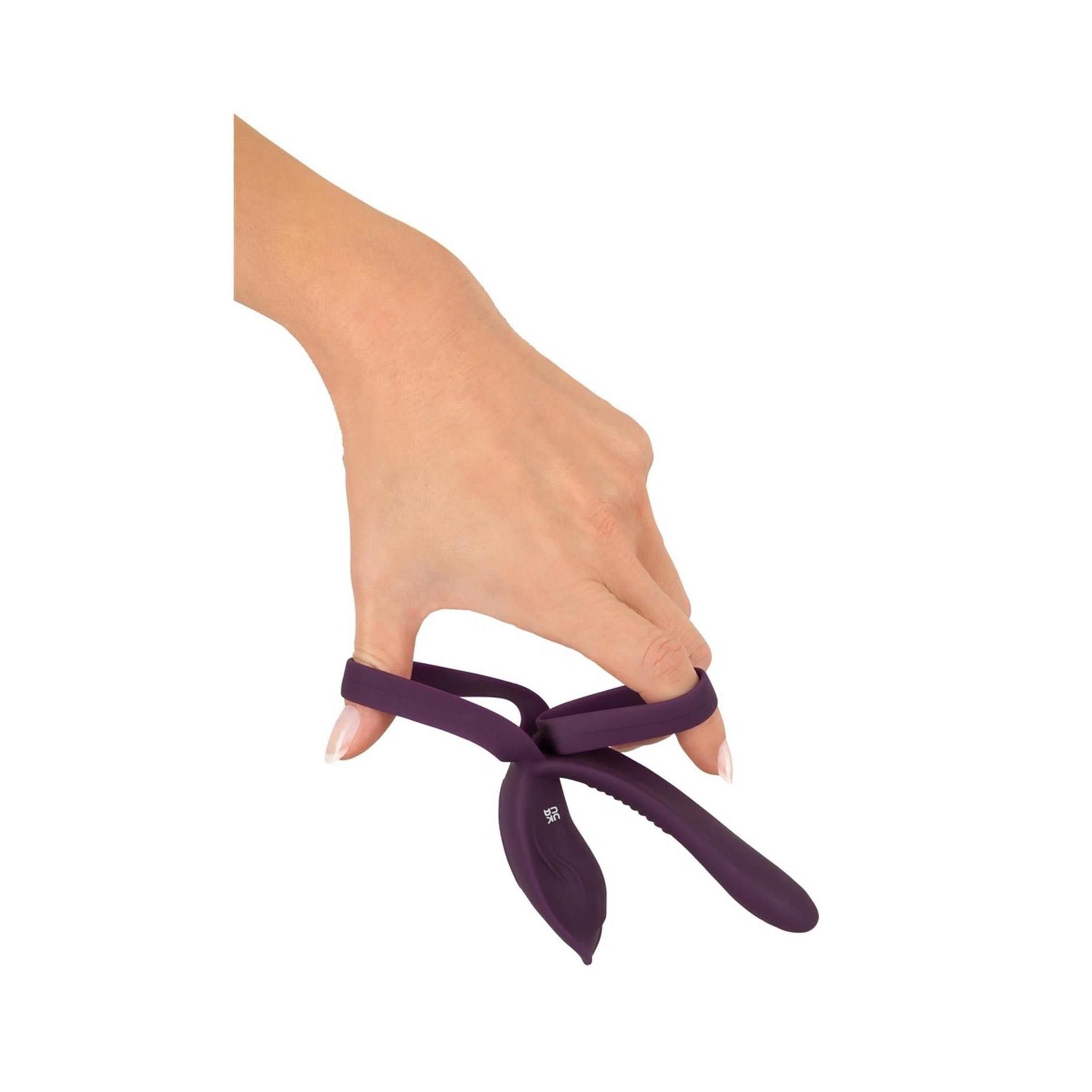 Hand hält lila Vibrator mit Ring. Ansicht von oben.