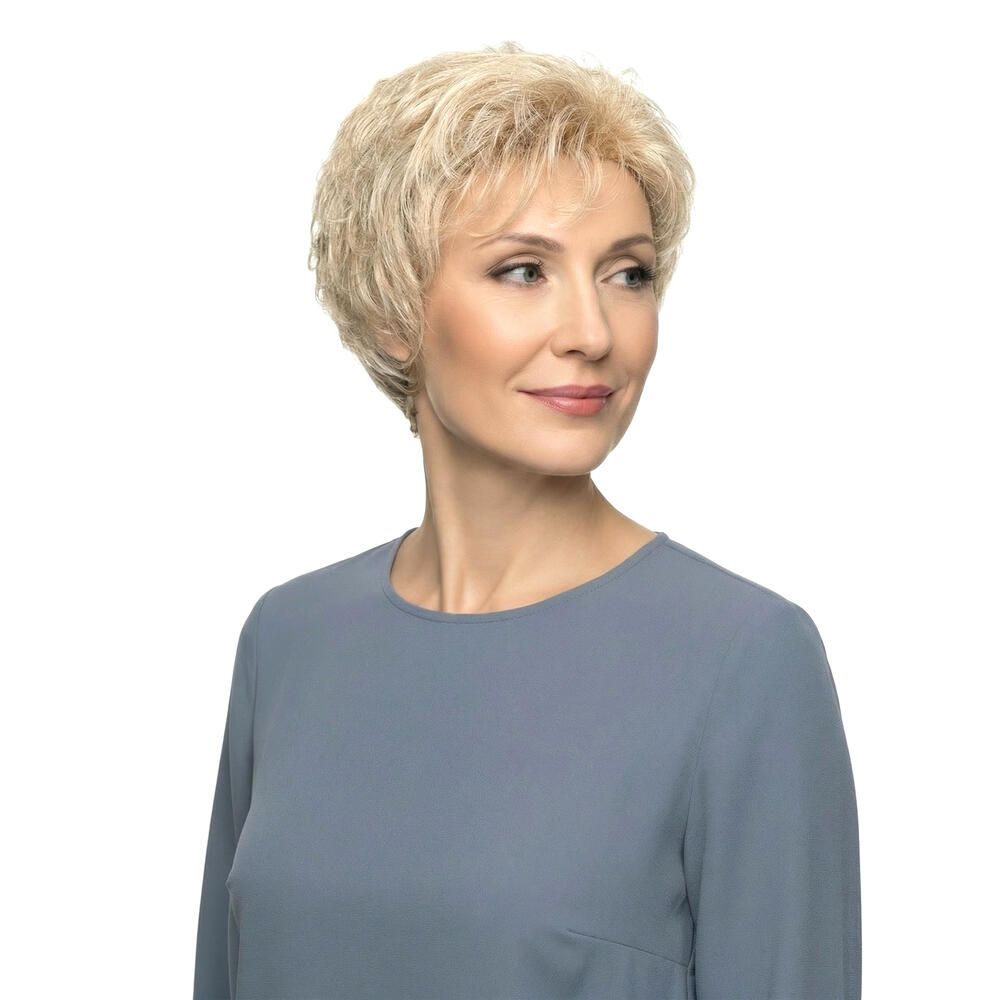 Blond gefärbte Perücke mit kurzem, gewelltem Haar. Die Perücke bedeckt den Kopf einer Frau, die nach rechts schaut.