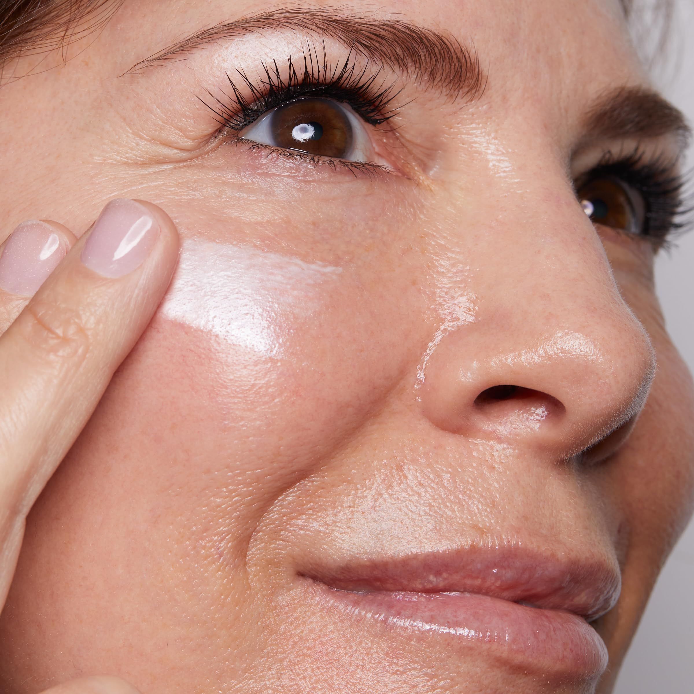 Gesicht mit aufgetragener Creme. Haut glänzt.