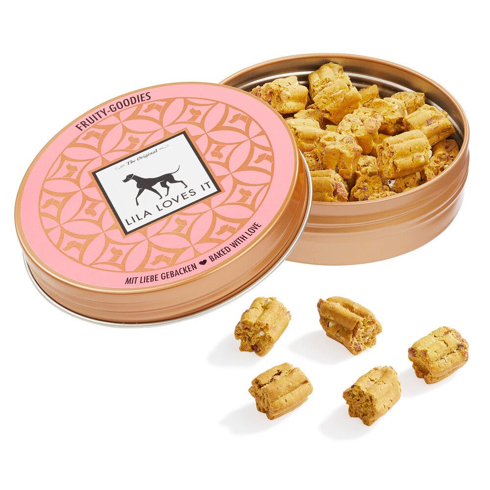 Geöffnete runde Dose mit Keksen. Rosa Deckel mit Logo. Aufschrift: Fruity-Goodies. 5 Kekse liegen daneben.