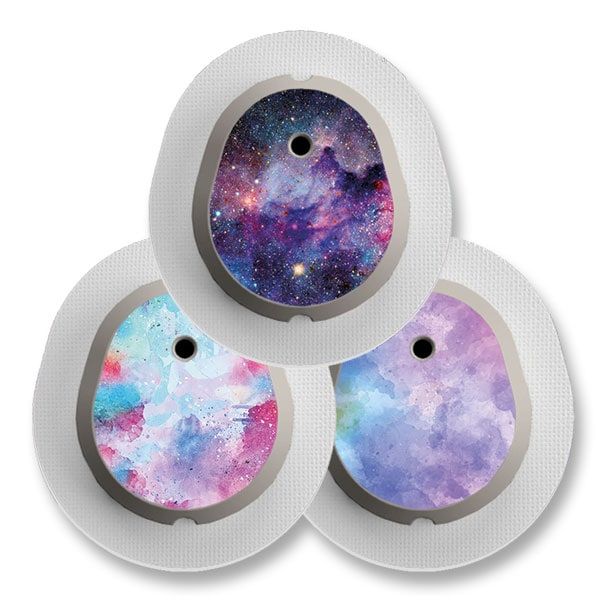 Drei runde Aufkleber mit farbigen Designs für ein medizinisches Gerät. Jedes hat ein Loch und einen silbernen Rand.