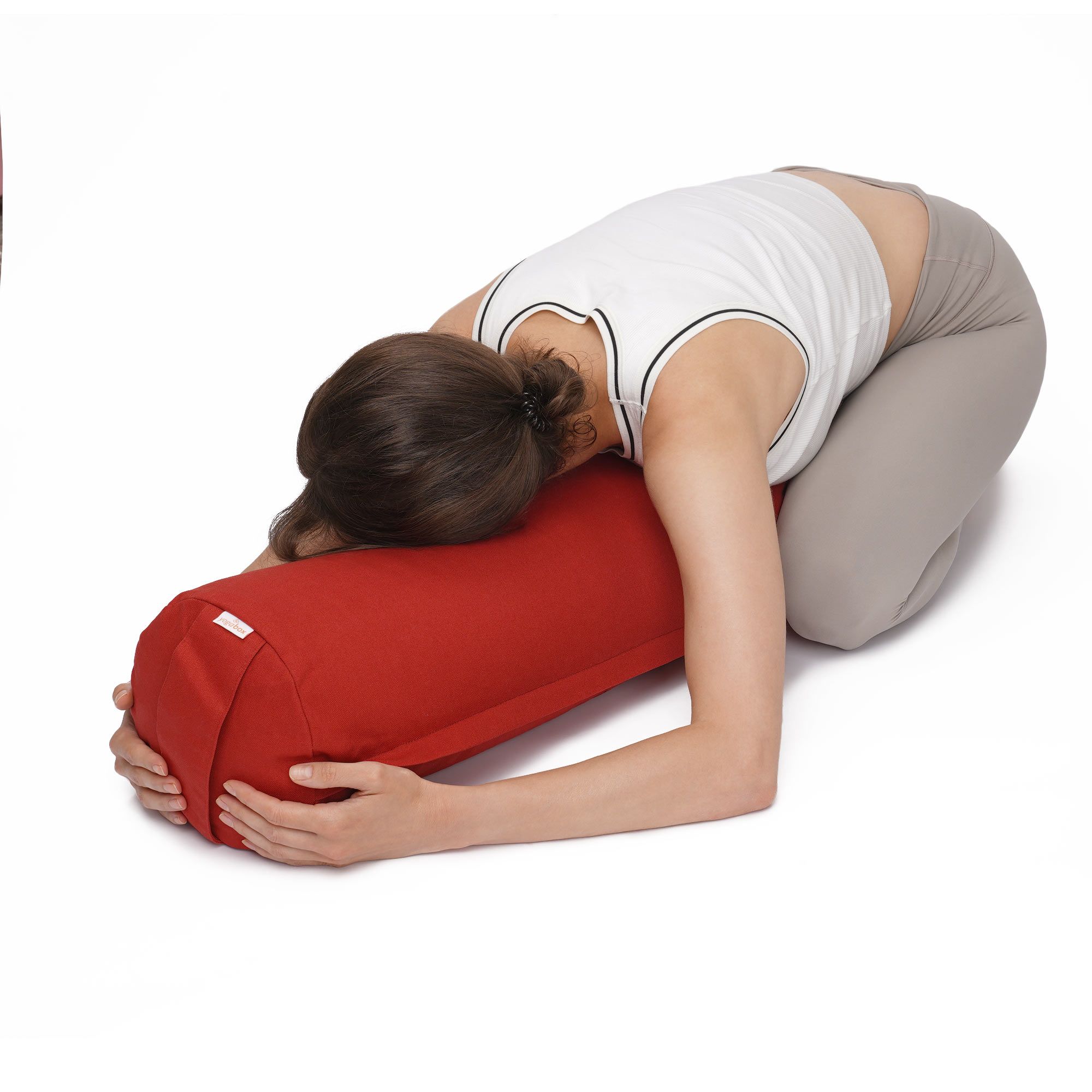 Frau in Kindhaltung auf einer roten Yogarolle liegend.