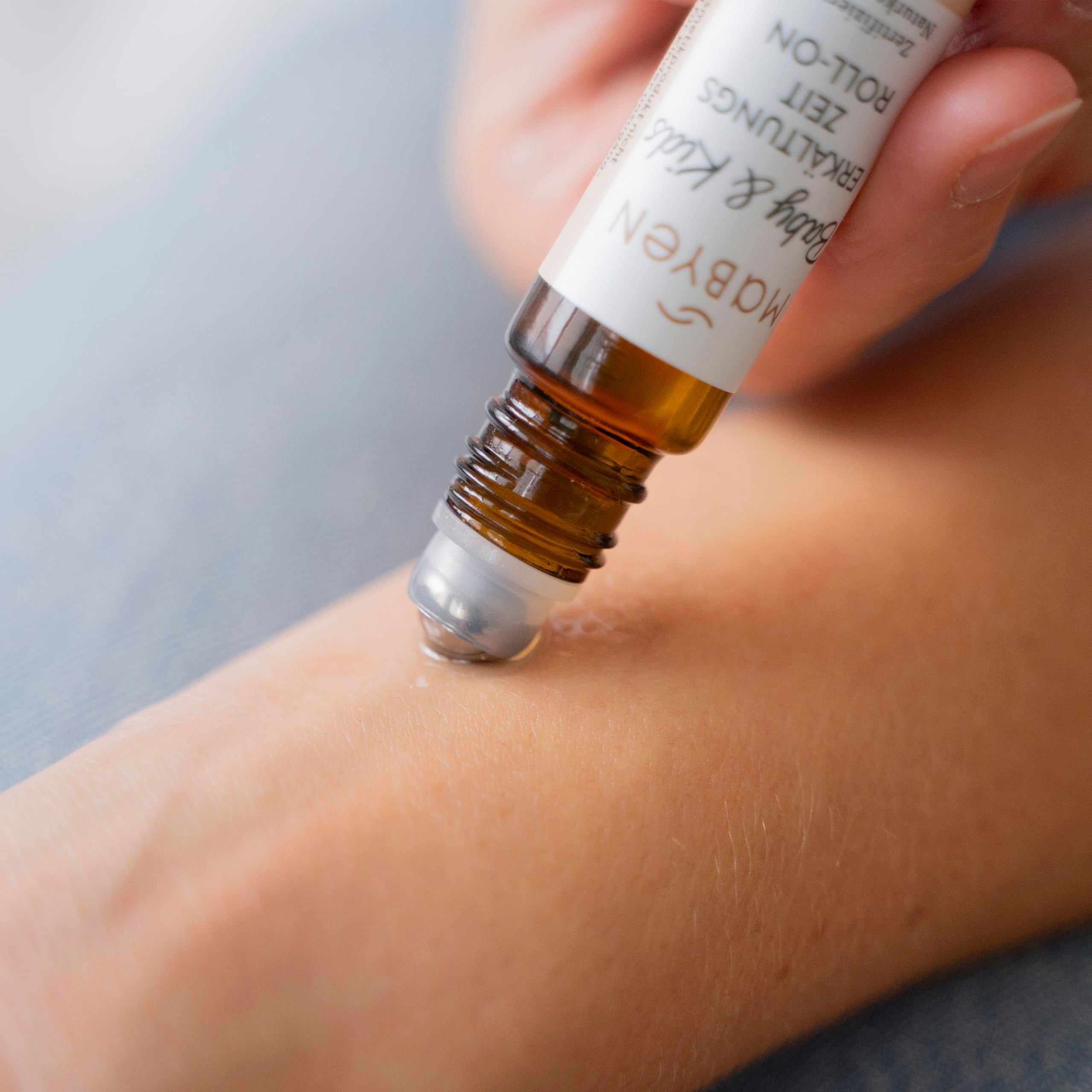 Person trägt Roll-on auf Handgelenk auf. Sichtbar: Roll-on-Kopf. Aufschrift: Baby & Kids Erkältungszeit Roll-on.