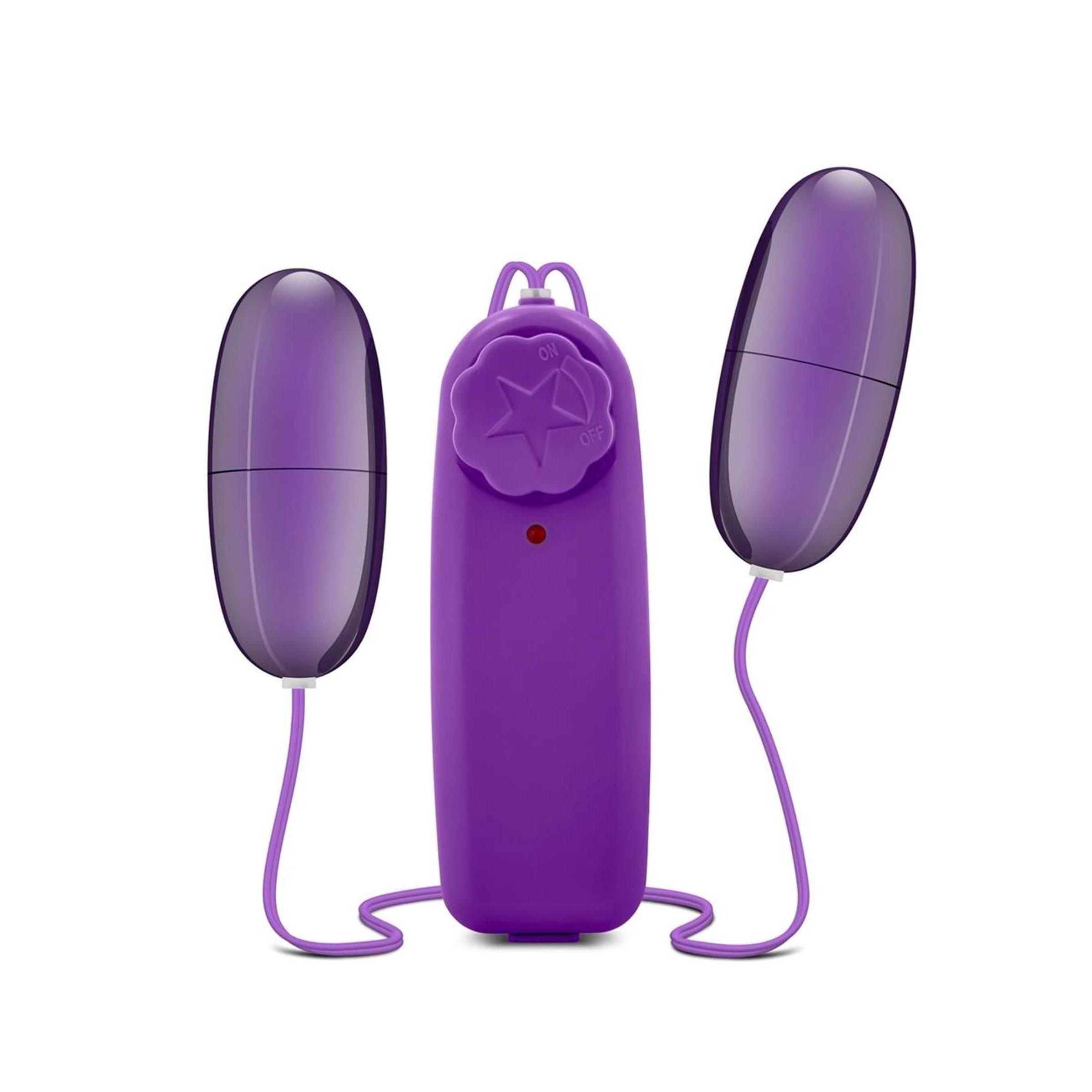 Lila Doppel-Ei-Vibrator. Zwei Eier und eine Fernbedienung mit Sternmuster. Kabel verbinden die Teile. Roter Knopf an der Fernbedienung.