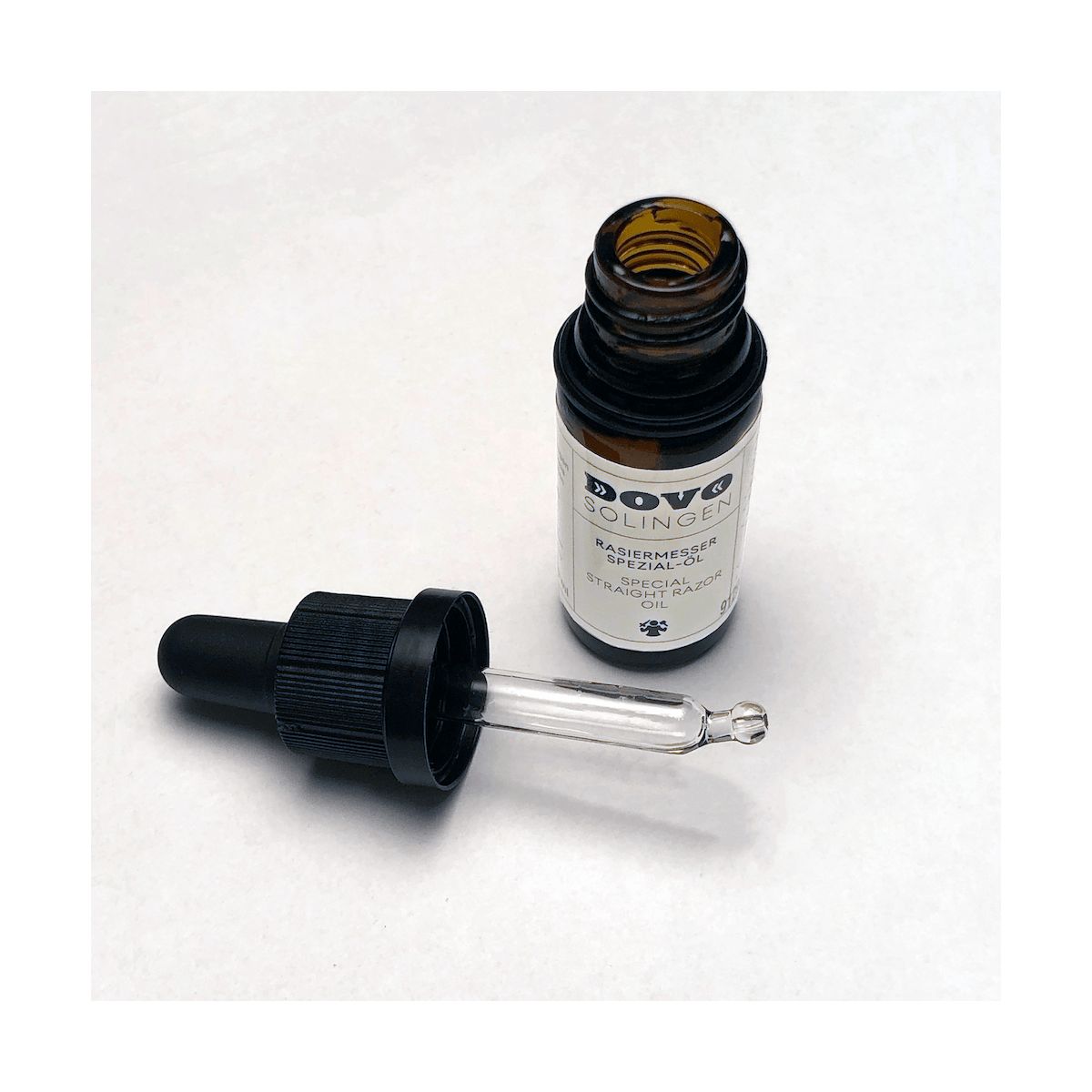 Braune Glasflasche mit schwarzem Deckel und Pipette. Etikett mit Schriftzug DOVO Solingen. Spezialöl für Rasiermesser.